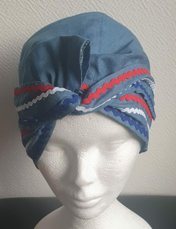 4.1Chapeau carabela en bleu marine sur une tenue traditionnelle haïtienne et cousu de zigzags tricolors. Taille uniforme. Entièrement conçu et réalisé aux ateliers AnjeroCréation à Paris. Prix : 29.95€.