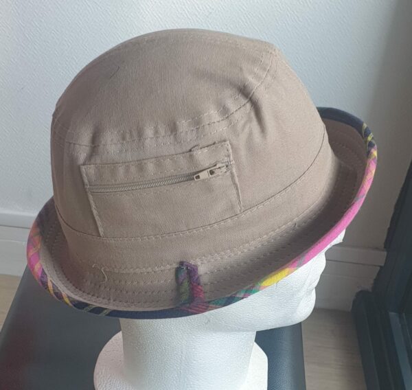 6.3Bob en marron clair sur un tissu 100% coton.  L'ajout de deux poches latérales zipées apporte une touche harmonieuse à ce couvre-chef. Les finitions en bordure sont en Madras et entièrement conçues puis réalisées aux ateliers AnjeroCréation à Paris.