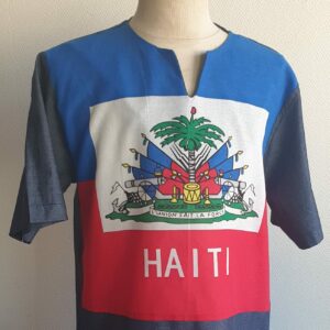 2.1Chemise tunique carabela en bleu dégradé sur une tenue traditionnelle haïtienne. Modèle en manche courte et taillé près du corps. Col arrondi avec une échancrure en son centre. Taille : S, M, L, XL. Prix : 49€. Cette pièce en tissu coton est entièrement confectionnée aux ateliers AnjeroCréation à Paris.