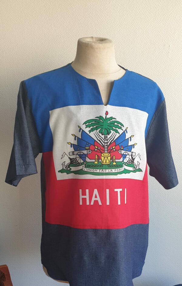 2.1Chemise tunique carabela en bleu dégradé sur une tenue traditionnelle haïtienne. Modèle en manche courte et taillé près du corps. Col arrondi avec une échancrure en son centre. Taille : S, M, L, XL. Prix : 49€. Cette pièce en tissu coton est entièrement confectionnée aux ateliers AnjeroCréation à Paris.