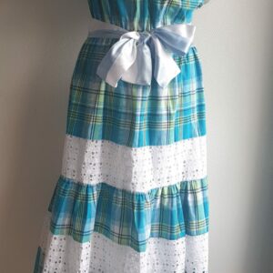 1.1Robe madras sur une couleur bleue turquoise cent pour cent coton. Dentelles et broderies anglaises ainsi que le col bardot sont autant de spécificités affirmant le caractère de la robe. Elle est de plus élastique à la taille conférant ainsi une entière liberté d'adaptabilité. Une ceinture en satin bicolore ajoute à sa valeur. Taille : S, M, L, XL. Prix : 199,95€. Ce produit est entièrement confectionné dans les ateliers AnjeroCréation à Paris.