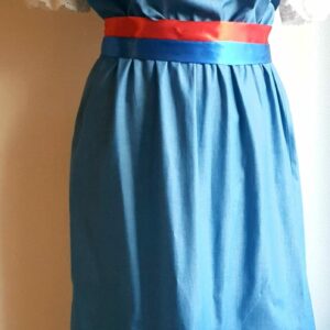 17.1Robe carabela en bleu clair sur une tenue traditionnelle aux manches courtes. Elle est composée entièrement de coton. Son style se distingue par une élasticité à la taille, un décoleté semi-plongeant, un maxi col bardot et de soyeuses broderies blanches anglaises aux êxtrèmités body. Les Zigzags ressérrés en bas et haut de robe proposés dans quatre couleurs de même que son fendu en son bas-milieu offrent ainsi une silhouette tout à fait originale. Cette robe est aussi livrée avec une ceinture bicolore rouge et bleue. Toutes les tailles sont proposées. Prix : 249.95€. Cette confection est entièrement conçue et réalisée dans les ateliers AnjéroCréation à Paris.