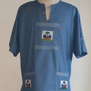 3.1Chemise homme carabela en coton sur une tenue traditionnelle haïtienne en bleu ciel. Col ras du coup arrondi et fendu au devant duquel, trois petits boutons coco se distinguent. Les trois poches sont décorées du drapeau Haïti. Ce produit aux manches courtes est entièrement conçu et réalisé aux ateliers AnjéroCréation à Paris. Taille : S, M, L, XL, XXL. Prix : 69.95€.