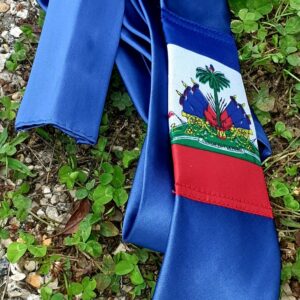 4.1Cravate sur un bleu foncé avec pochette et se caractérisant sur son devant par la distinction du drapeau Haïti. Prix  : 23€.