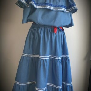 9.1Ensemble carabela en bleu avec manches courtes sur une tenue traditionnelle haïtienne. Cette confection  est pourvue de deux pièces appareillées d'une ceinture bicolore rouge et bleue. Cet ensemble est entièrement conçu et réalisé dans les ateliers AnjeroCreation à Paris. Taille : S, M, L, XL, XXl. Prix : 179.95€