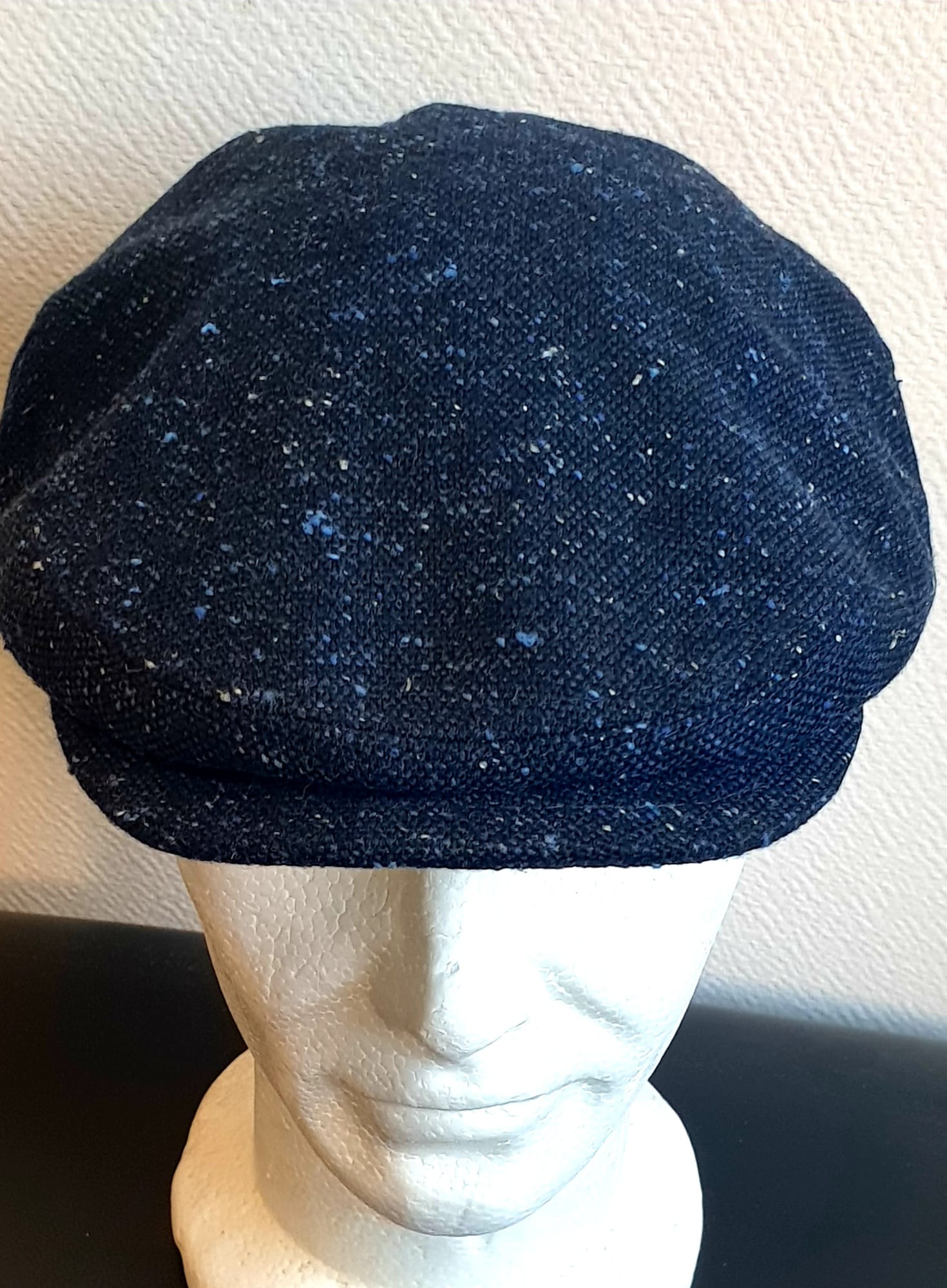 5.1Béret en bleu moucheté entièrement doublé avec un dessus de calotte composé de laine. Le fond de calotte en polyester est matelassé en noir. Ce couvre-chef confortable et agréable à porter a été confectionné en Italie. Toutes les tailles de tour de tête sont disponibles. Prix : 27.50€.