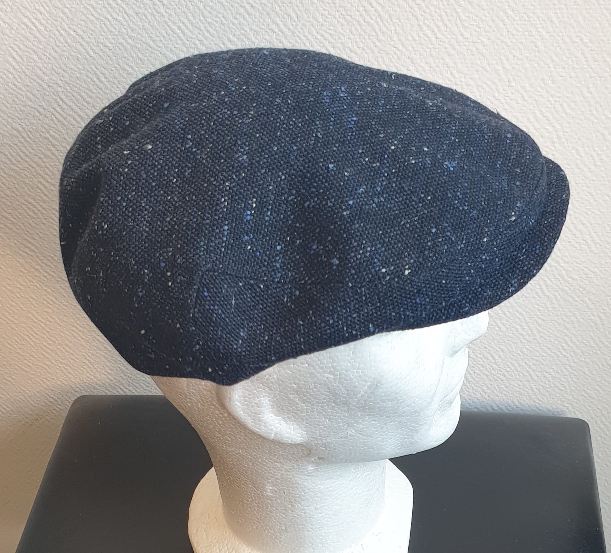 5.2Béret en bleu moucheté entièrement doublé avec un dessus de calotte composé de laine. Le fond de calotte en polyester est matelassé en noir. Ce couvre-chef confortable et agréable à porter a été confectionné en Italie. Toutes les tailles de tour de tête sont disponibles. Prix : 27.50€.