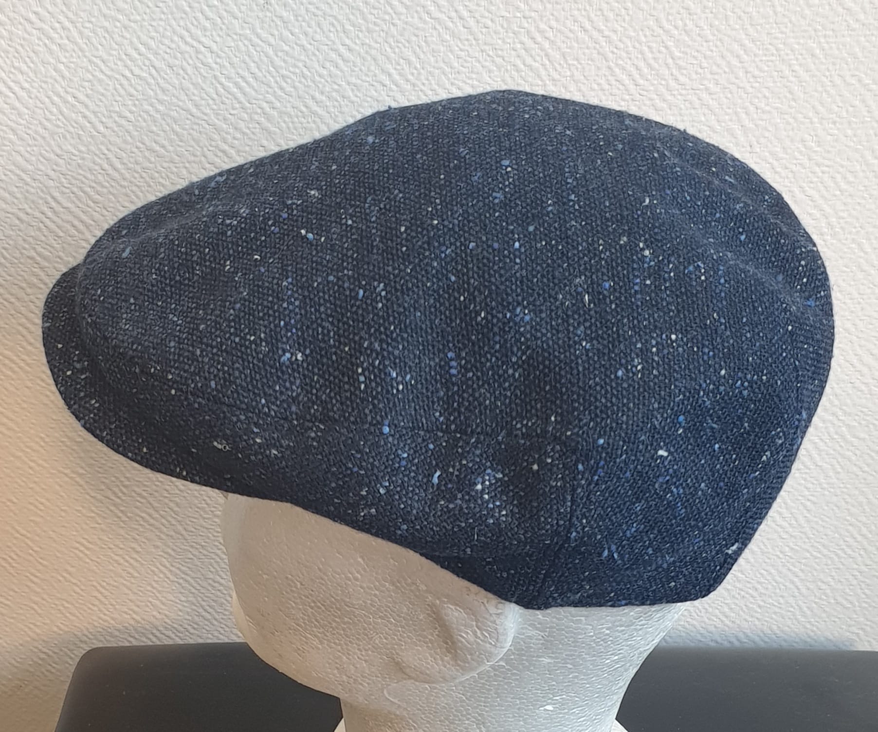 5.3Béret en bleu moucheté entièrement doublé avec un dessus de calotte composé de laine. Le fond de calotte en polyester est matelassé en noir. Ce couvre-chef confortable et agréable à porter a été confectionné en Italie. Toutes les tailles de tour de tête sont disponibles. Prix : 27.50€.