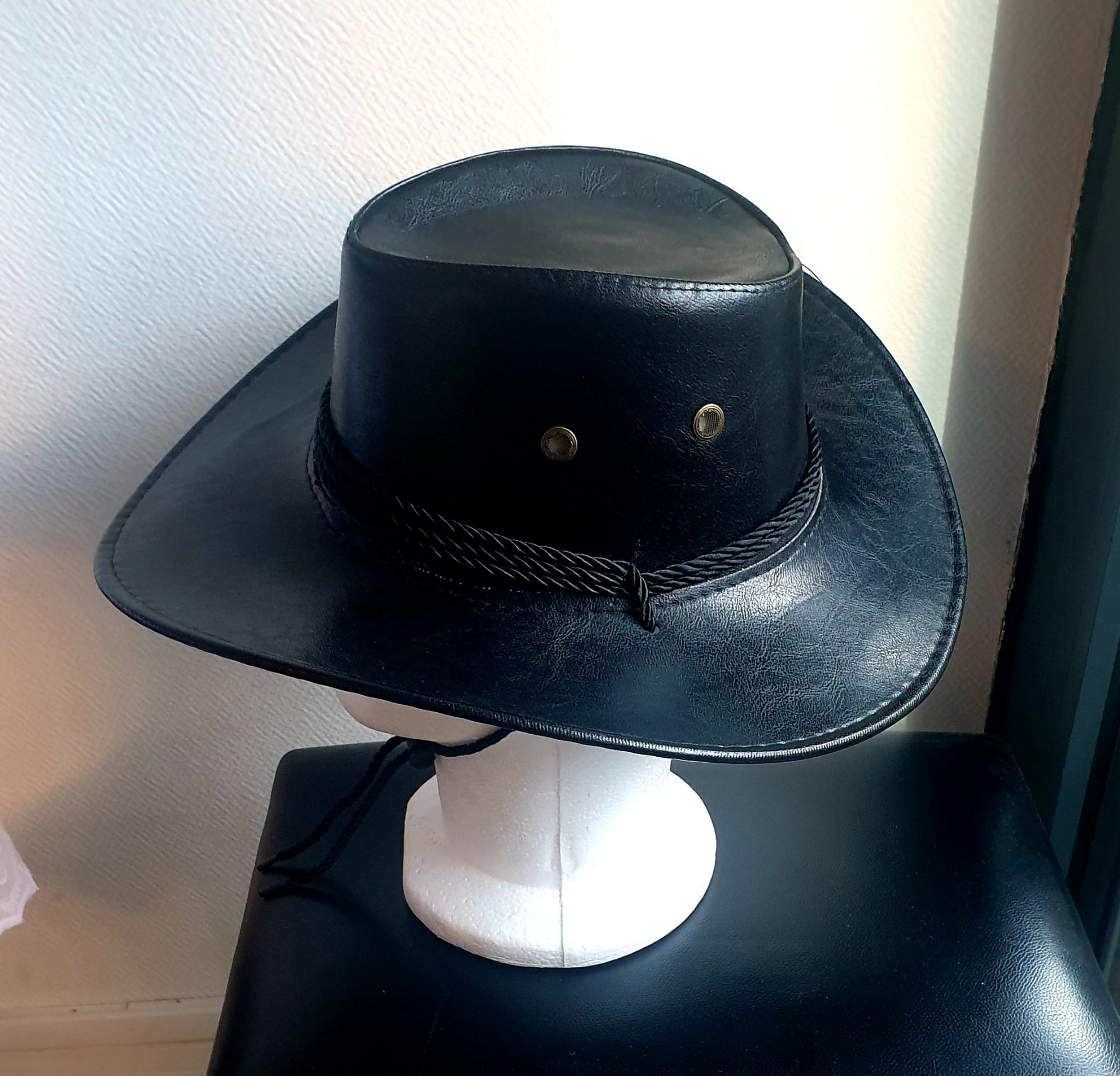 17.4Chapeau cowboy large bord en noir et en PVC ajoute un effet simili cuir. Un cordon de serrage noir en coton permet un bon maintien et assure une possible inclinaison sur l'arrière cou sans détachement. Un style très original et typique lui est conféré. Prix : 19.95€.