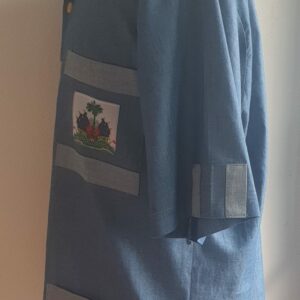 4.1Chemise carabela en tissu cent pour cent coton. Trois poches dont une munie du drapeau haïtien. Tissu travaillé à la main avec une petite poche cousue sur manche courte. Un Col classique a été choisi pour ce modèle avec un ensemble linéaire de boutons en bois coco verticaux. Cette chemise est entièrement conçue et réalisée dans les ateliers AnjeroCréation à Paris. Prix : 79.95€.