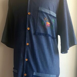 6.1Chemise carabela en bleu marine à manches courtes. Tissu Chambray tout en coton. La coupe soigneusement ceintrée près du corps est accompagnée d'un col boutonné sur le devant. Cette confection est entièrement conçue et réalisée aux ateliers AnjeroCréation à Paris. Prix : 75€.