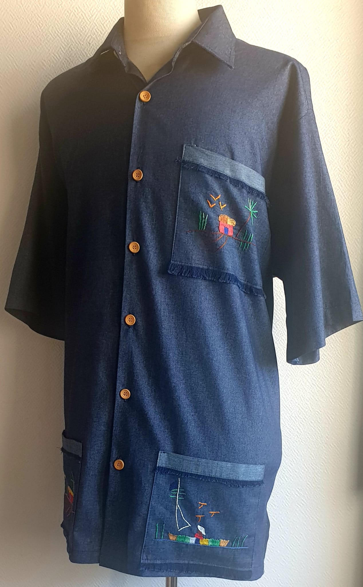 6.1Chemise carabela en bleu marine à manches courtes. Tissu Chambray tout en coton. La coupe soigneusement ceintrée près du corps est accompagnée d'un col boutonné sur le devant. Cette confection est entièrement conçue et réalisée aux ateliers AnjeroCréation à Paris. Prix : 75€.