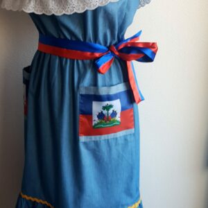 22.1 Robe Carabela mi-longue pour enfant sur une tenue traditionnelle haïtienne. Son bleu dominant et les serpentines décoratives découvrent un col bardot ajusté harmonieusement. Ce modèle cent pour cent coton laisse entrevoir de belles dentelles anglaises blanches en bas de robe. Taille : 12 ans. Prix : 149.95€.  Ce produit est conçu et réalisé aux ateliers AnjeroCreation à Paris.