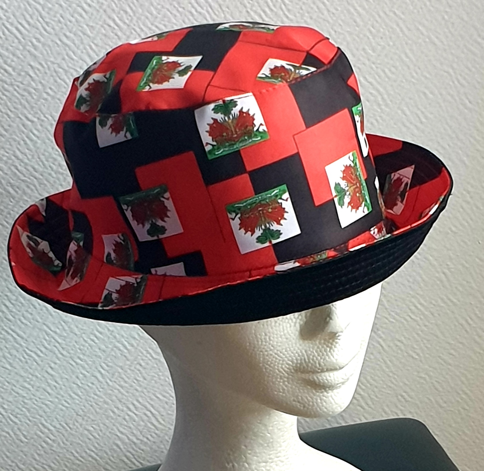 1.2Bob en rouge arborant le drapeau Haïti tout autour en extérieur. Léger à porter, ce couvre-chef présente aussi l'avantage d'être réversible tout en noir avec une passe permettant très facilement d'ajuster l'apparence du style. Il se distingue par une hauteur de montant qui lui confère son originalité. Taille unique. Prix : 19,95€.