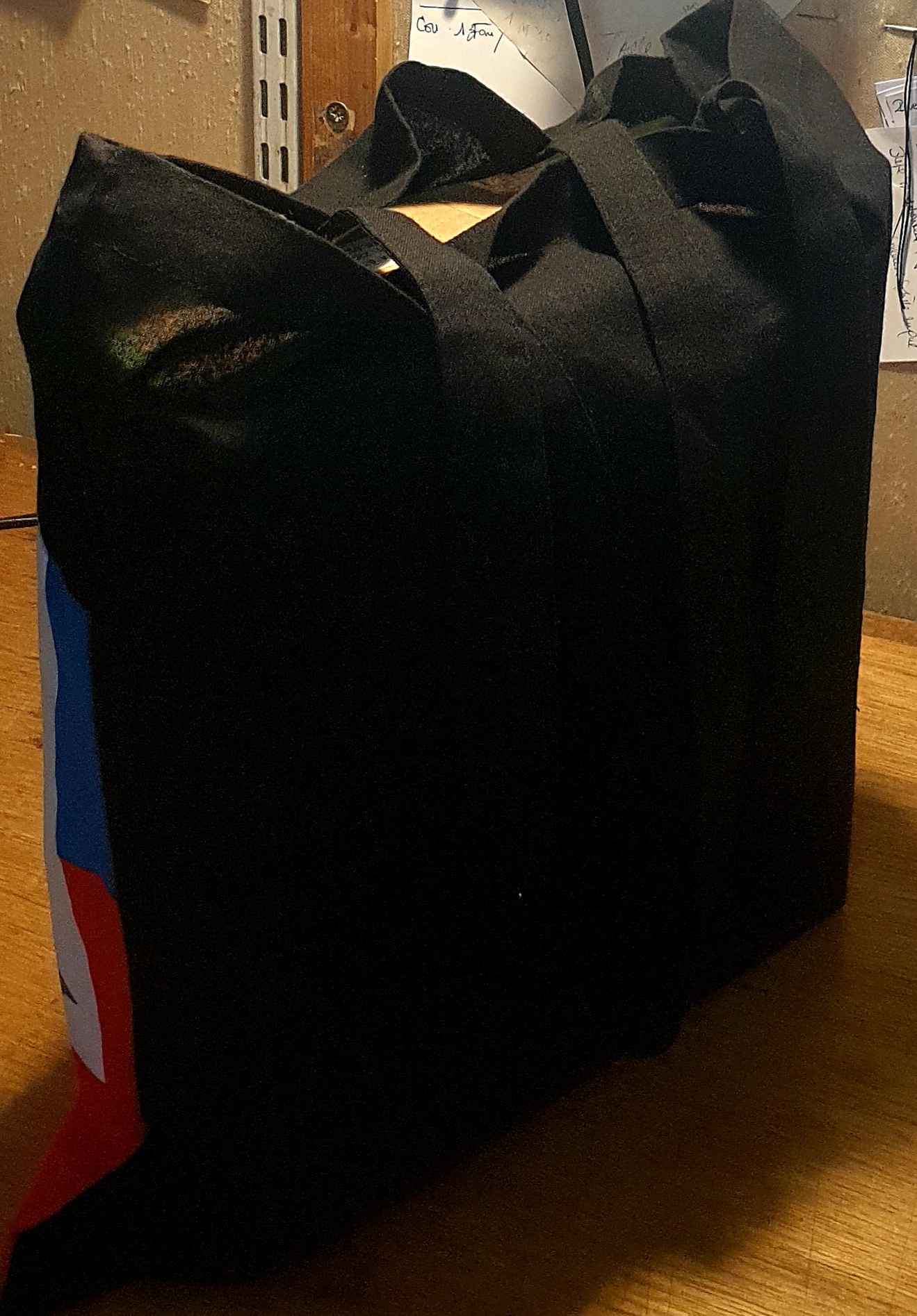 1.3Tote-bag en coton sur un extérieur bleu rouge orné du drapeau haïtien. Son intérieur est tout en noir. Ce produit es muni d'une élégante anse de bonne hauteur aux fins de facilité son port. Entièrement conçu et réalisé aux ateliers AnjeroCréation à Paris. Prix : 19,95€.