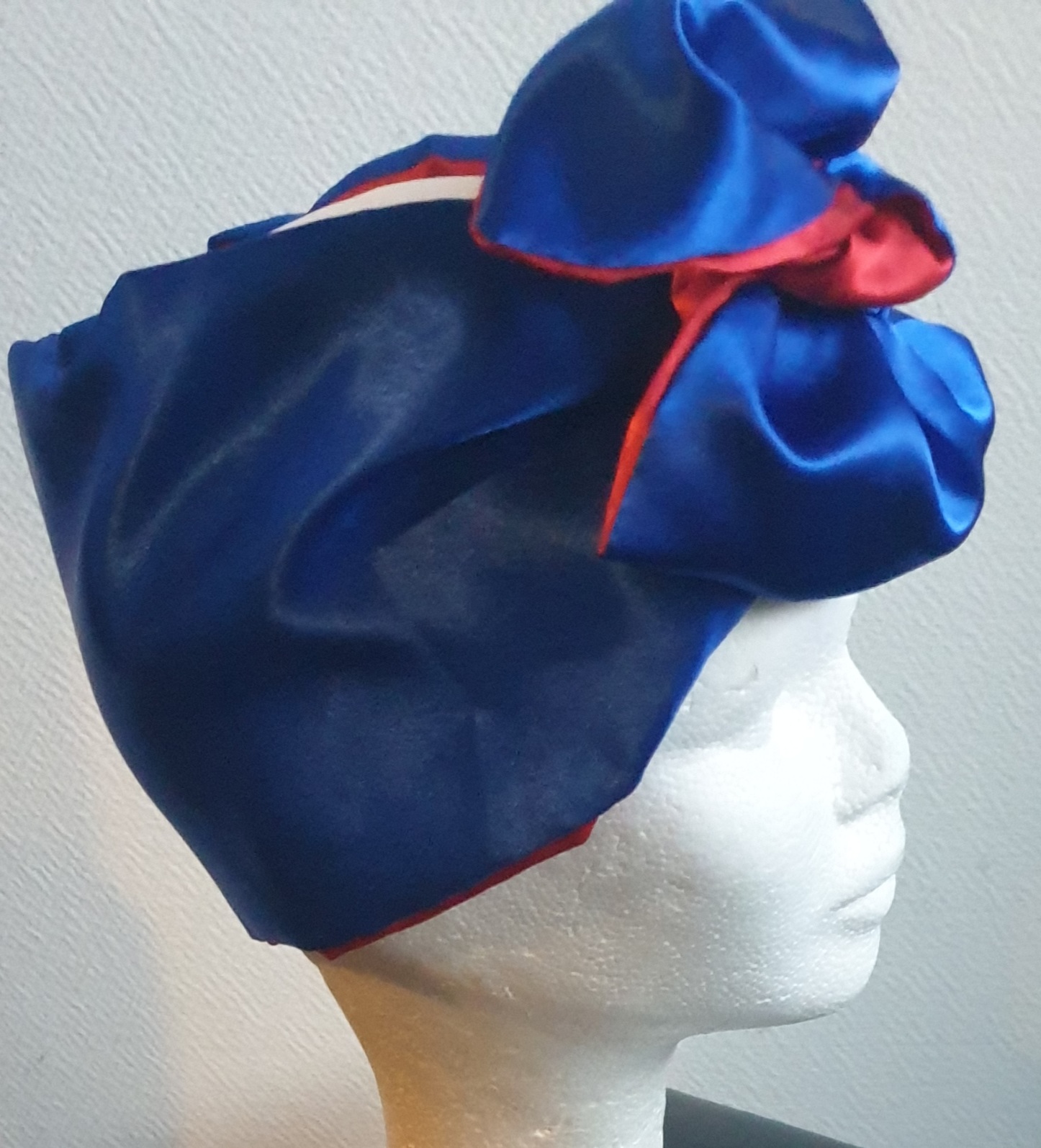 21.5Bandeau serre-tête bicolore bleu rouge en satin. Ce produit présente la particularité d'être réversible et de se nouer sur la tête avec une grande simplicité. Dimension : 100cm x 18cm. Taille unique. Prix : 29.95€. Entièrement imaginé, conçu et réalisé aux ateliers AnjeroCréation à Paris.
