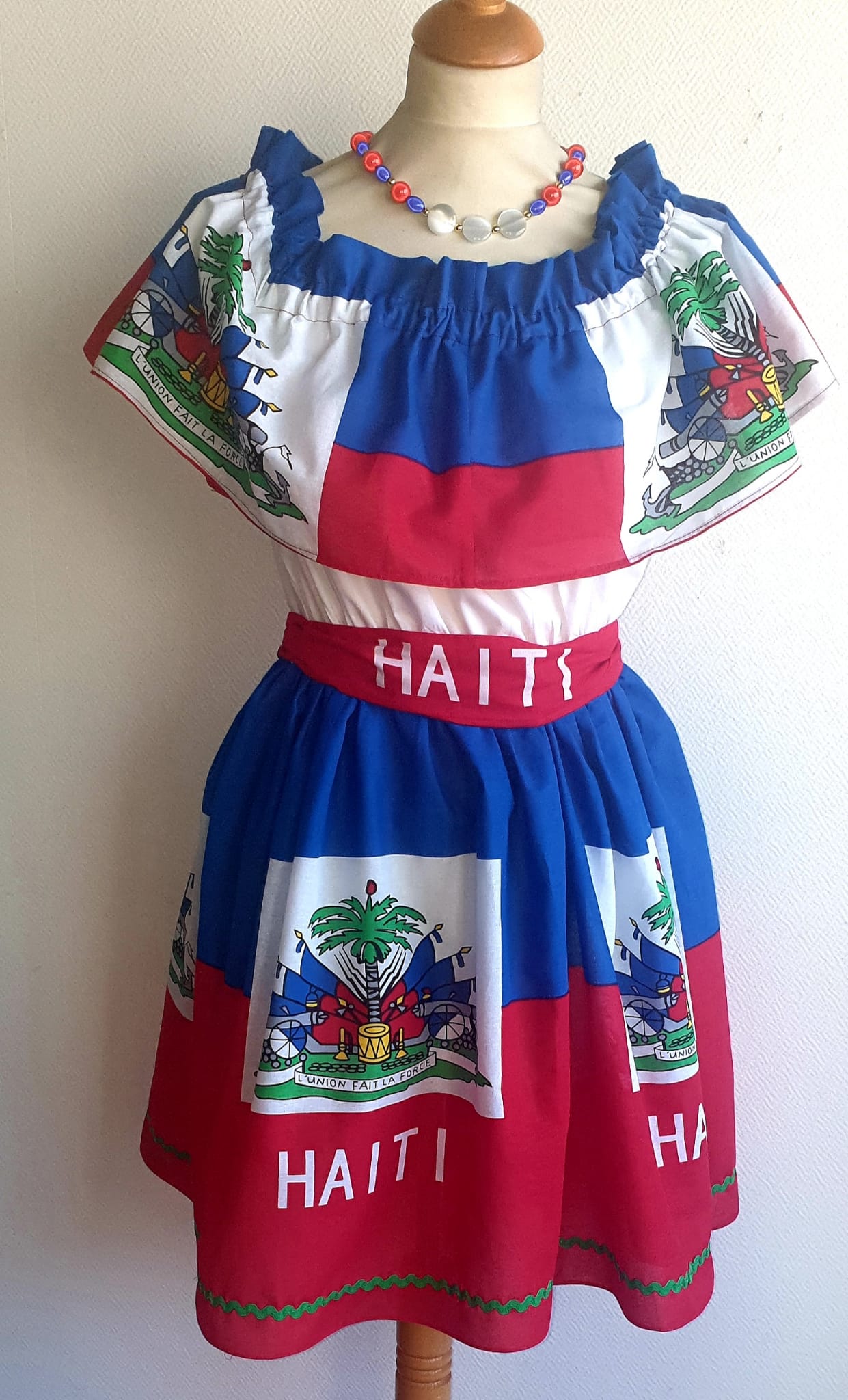 33.2Robe prestige haïtienne tricolore élastique à son col Bardot, à la taille. Tissu cent pour cent coton. Longueur de jupe approchée à 50cm.Prix 169.95€. Cette robe est entièrement confectionnée et conçue aux ateliers ANJEROCREATION à Paris.