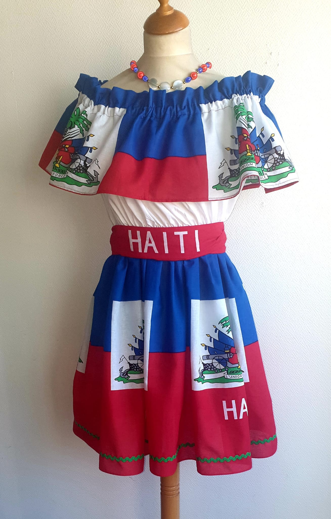 33.4Robe prestige haïtienne tricolore élastique à son col Bardot, à la taille. Tissu cent pour cent coton. Longueur de jupe approchée à 50cm.Prix 169.95€. Cette robe est entièrement confectionnée et conçue aux ateliers ANJEROCREATION à Paris.