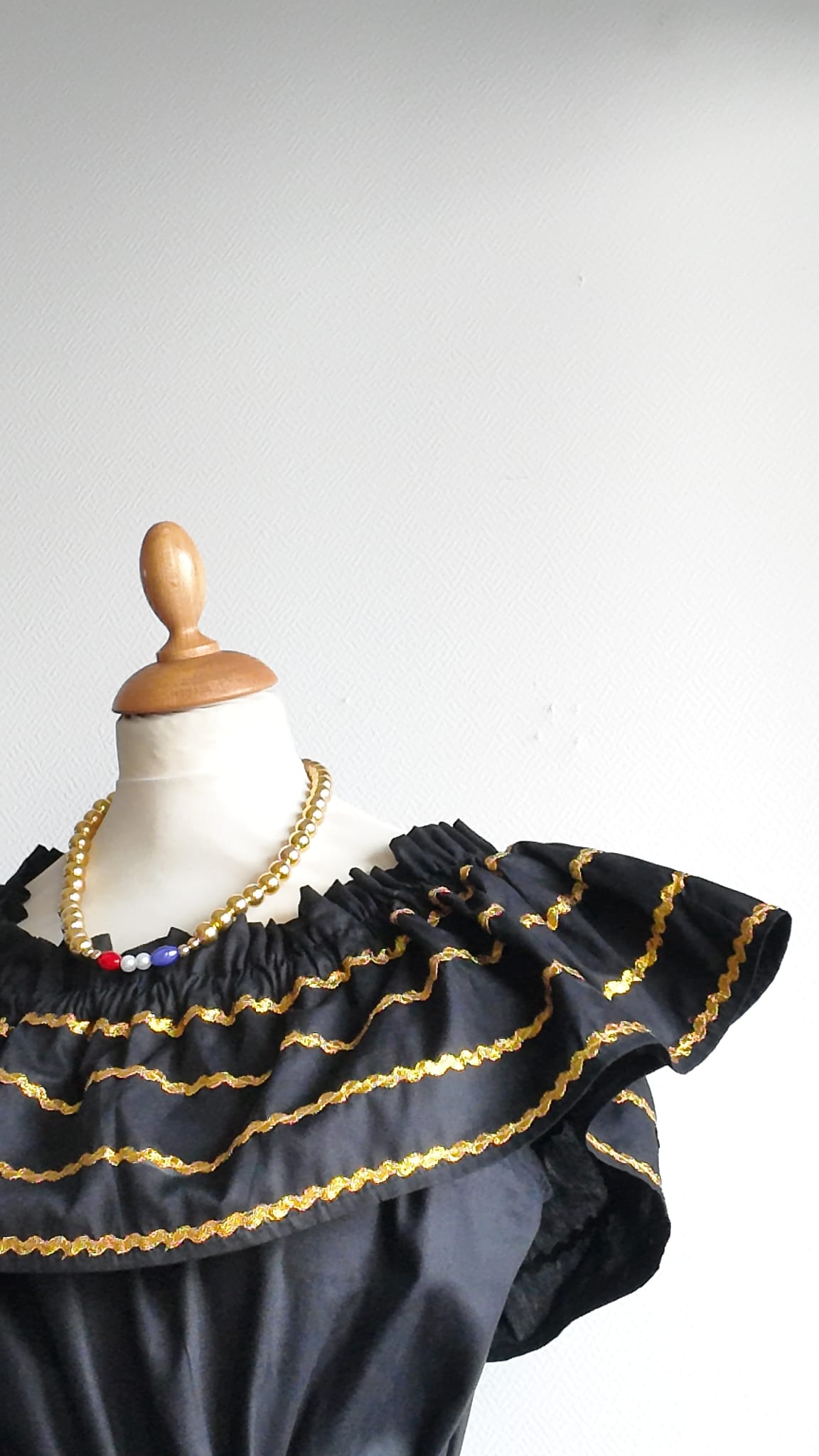 26.3Robe carabela en noire, tissu popeline de coton. Élastique à la taille. Zigzags dorés. L'ajout d'une ceinture décorée marque la taille et apporte une touche harmonieuse à la silhouette. Modèle entièrement conçu et réalisé aux ateliers AnjeroCréation à Paris. Prix : 329.95€